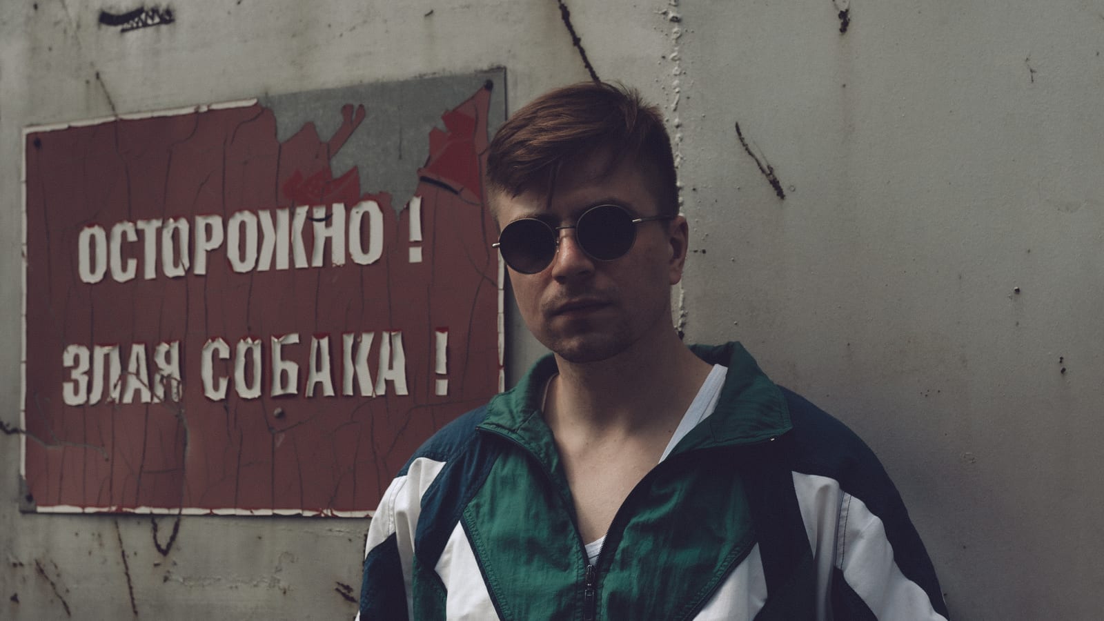 Олег Иванцов у бетонной стены с табличкой